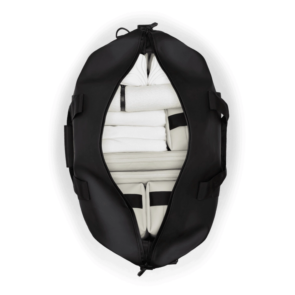 Vista dall'alto dell'interno capiente e organizzato con asciugamani e accessori da viaggio.