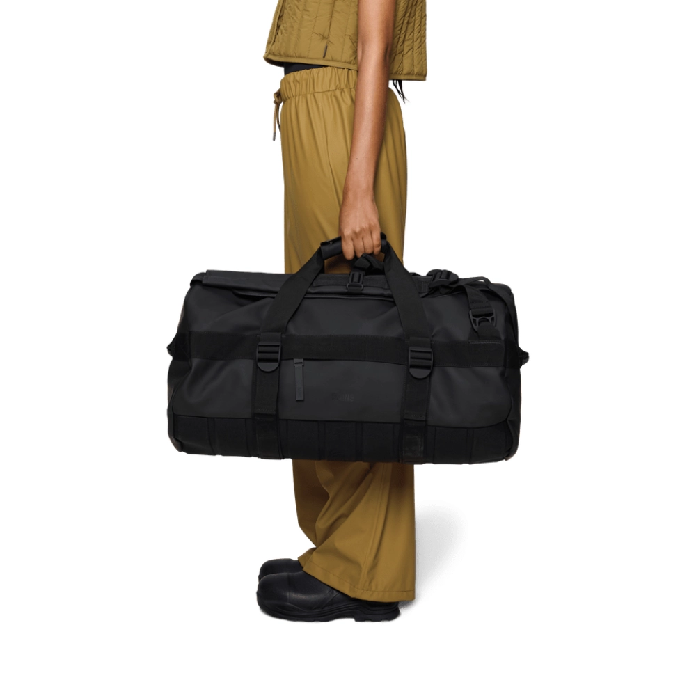 Borsone nero portato a mano orizzontalmente per mostrare le proporzioni e l'usabilità.