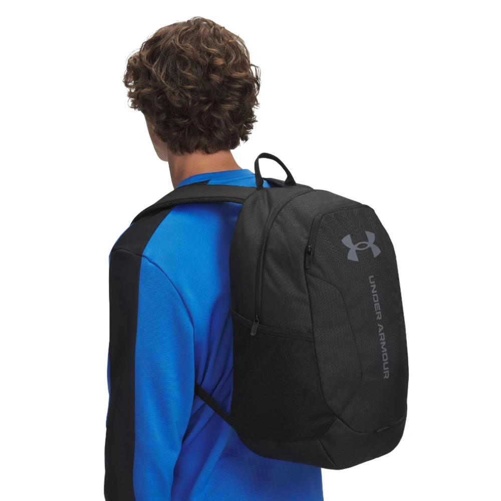 Ragazzo di spalle che indossa lo zaino sportivo nero, mostrando la vestibilità e gli spallacci imbottiti.