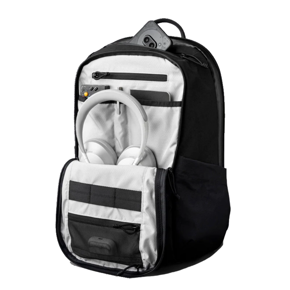 Scomparto principale spazioso e organizzato contenente cuffie over-ear, dispositivo da gioco e accessori.