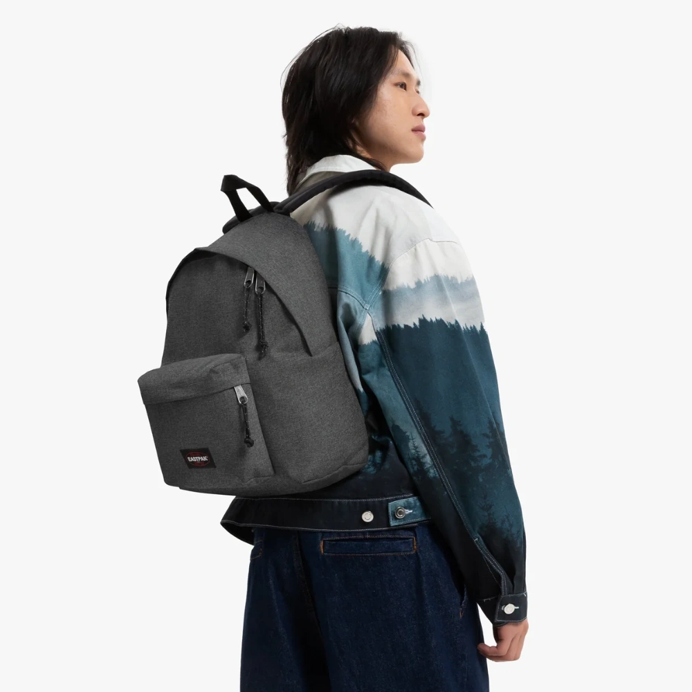 Zaino in tessuto denim nero indossato a spalla con spallacci imbottiti regolabili.