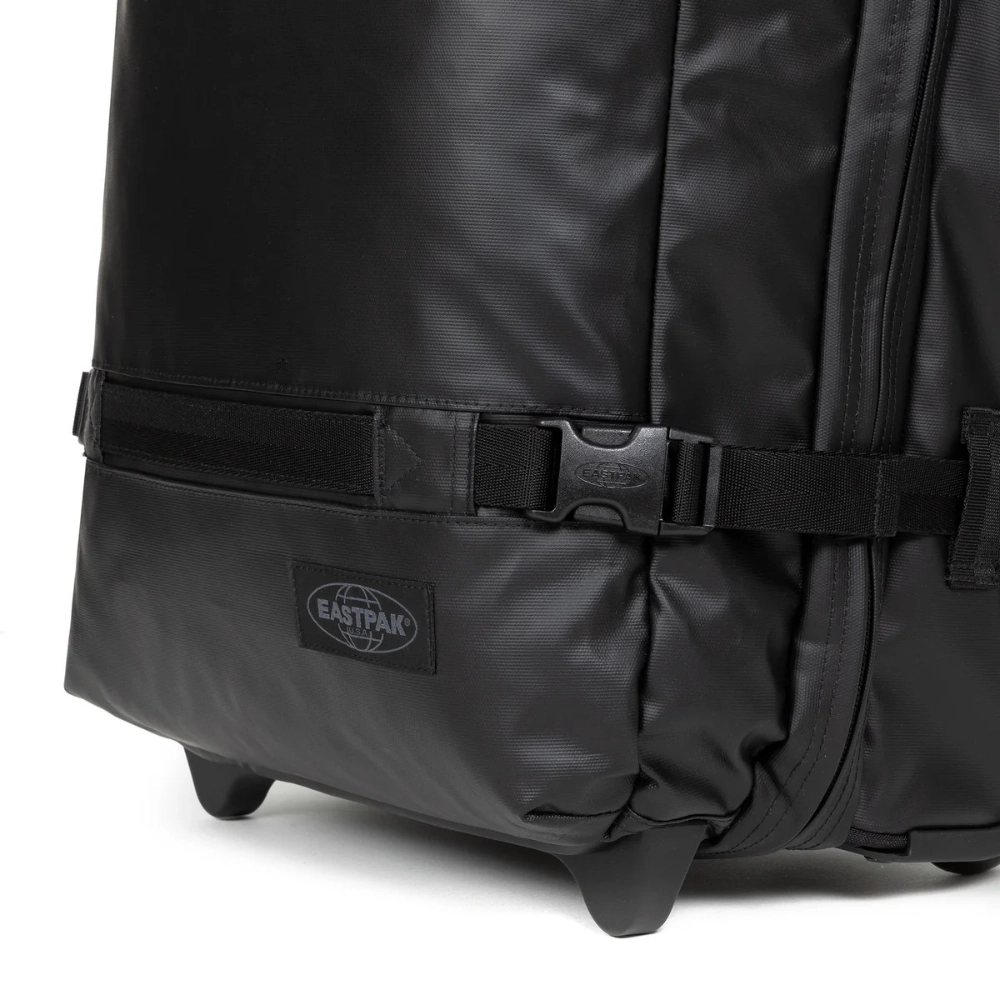 Dettaglio del materiale cerato impermeabile nero con cinghia di compressione e logo.