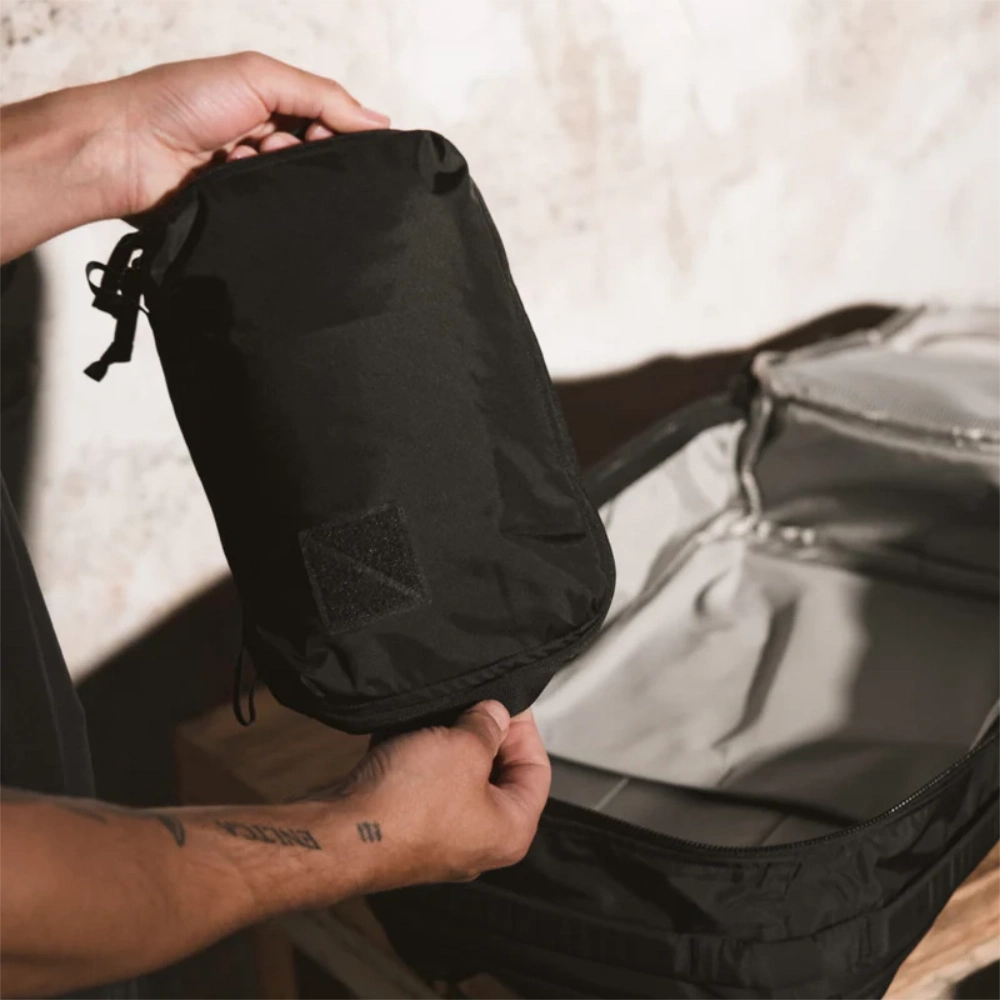 Posizionamento del cubo da viaggio nero da 4 litri all'interno del bagaglio.