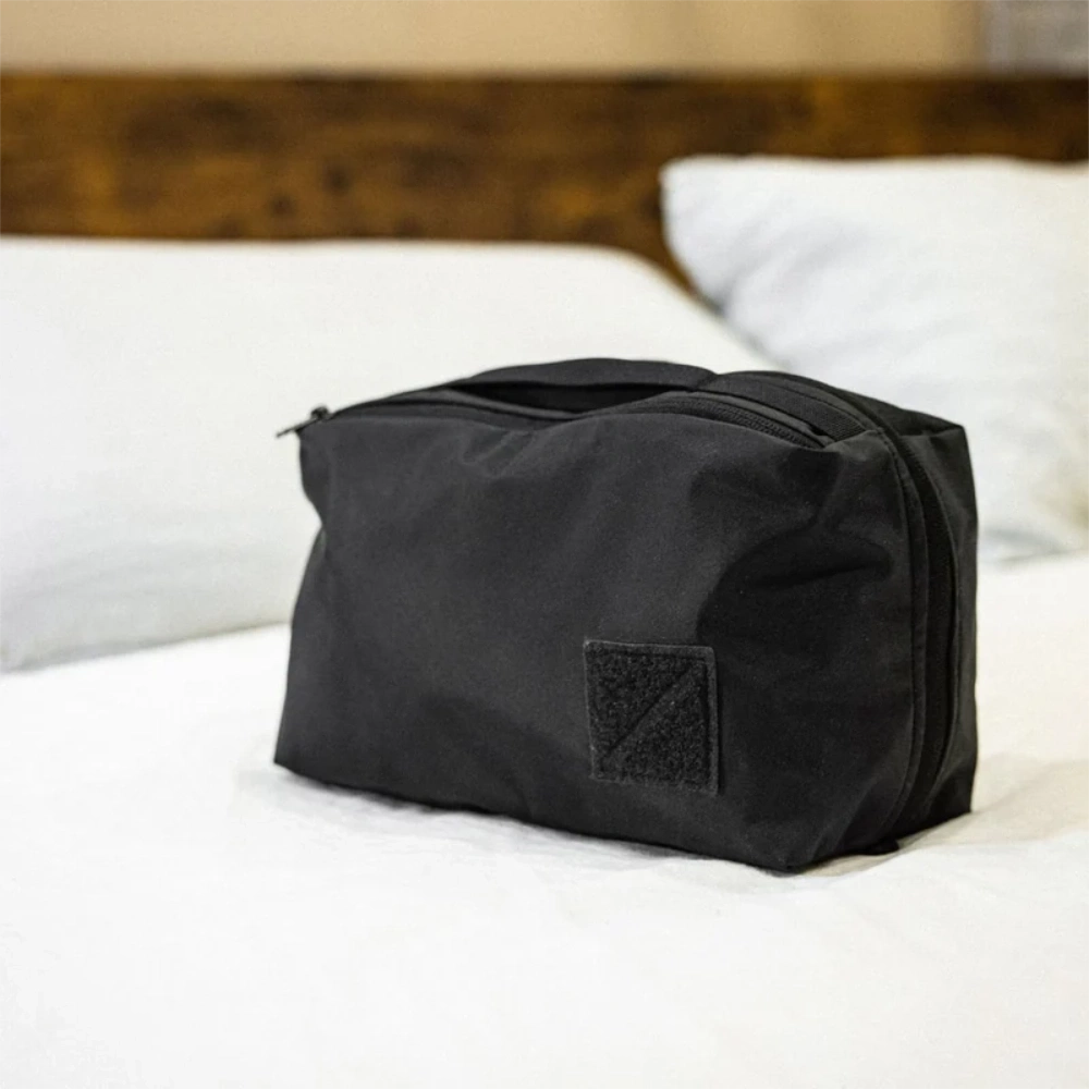 Cubo organizzatore nero chiuso riposto su un letto matrimoniale.