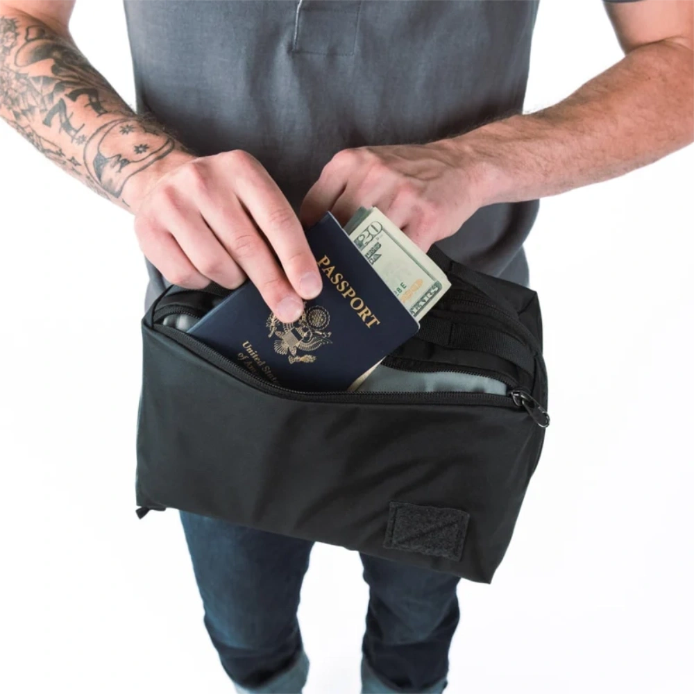 Uomo che inserisce passaporto e banconote nella tasca esterna con cerniera dell'organizer.