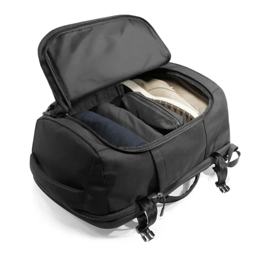 Scomparto principale aperto dall'alto con scarpe e indumenti organizzati per il viaggio.
