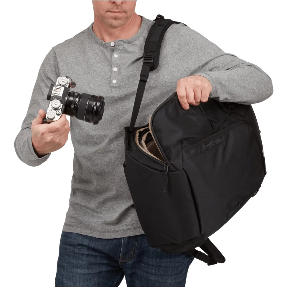 Fotografo che estrae la macchina fotografica sfruttando l'accesso laterale rapido dello zaino.
